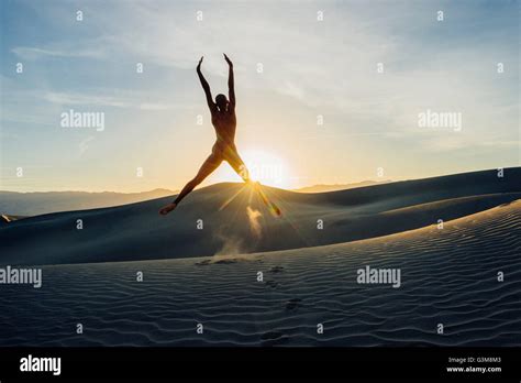 Nackte Frau in Wüste erhobenen Armen in der Luft springen Stockfoto Bild Alamy