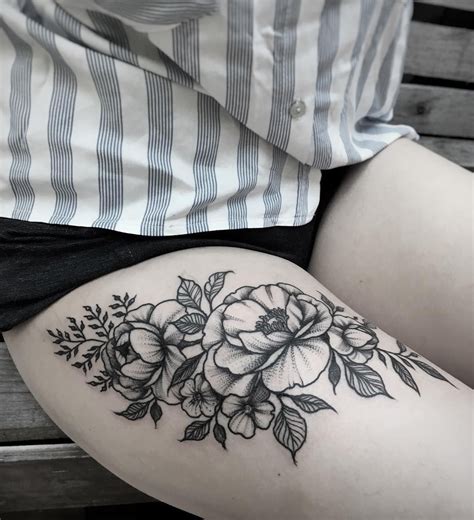 A Womans Thigh With Black And White Flowers On The Lower Part Of Her Leg