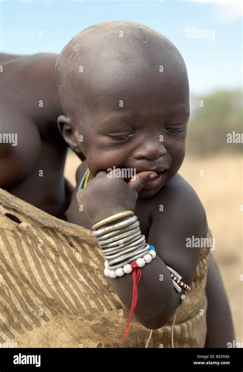 A Mursi Child Is Carried Safely In Her Mothers Decorated Leather