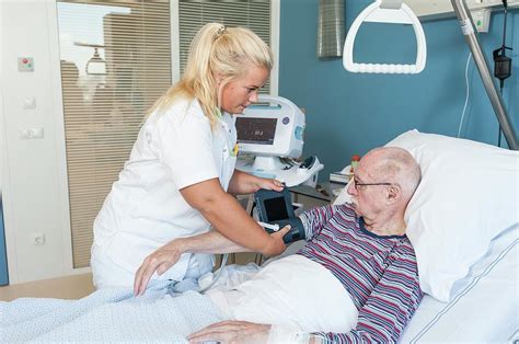 Nurse Taking Senior Mans Blood Pressure Photograph By Arno Massee