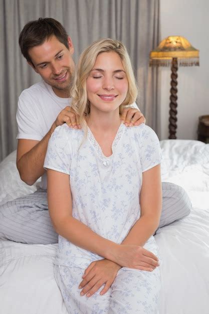 Premium Photo Smiling Man Massaging Womans Shoulders In Bed