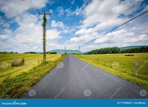 Country Road With Distant Mountains And Farm Fields In The Rural Stock