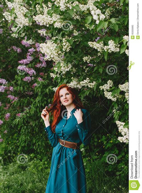 The Red Haired Girl Is Standing Near The Lilac Bush Stock Photo Image