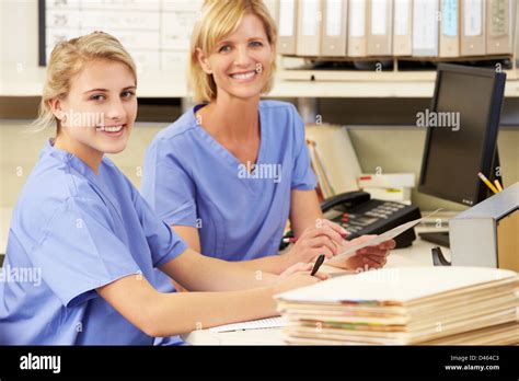 Two Nurses Working At Nurses Station Stock Photo Alamy