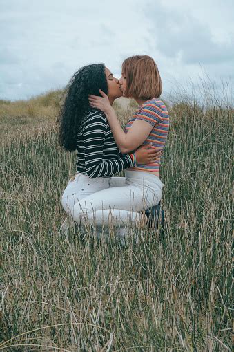Twee Lesbische Vrouwen Die Bovenop Elkaar Kussen Een Meisje Is Latino En Een Is Kaukasisch Beeld