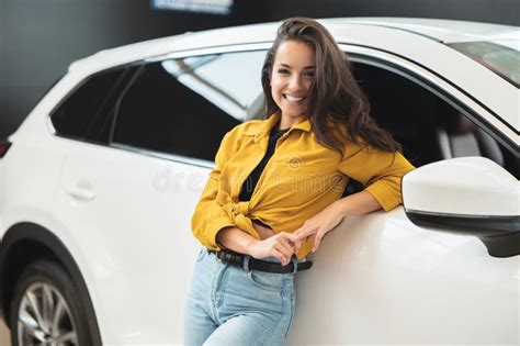 Beautiful Brunette Woman Looking For New Car In Dealership Center