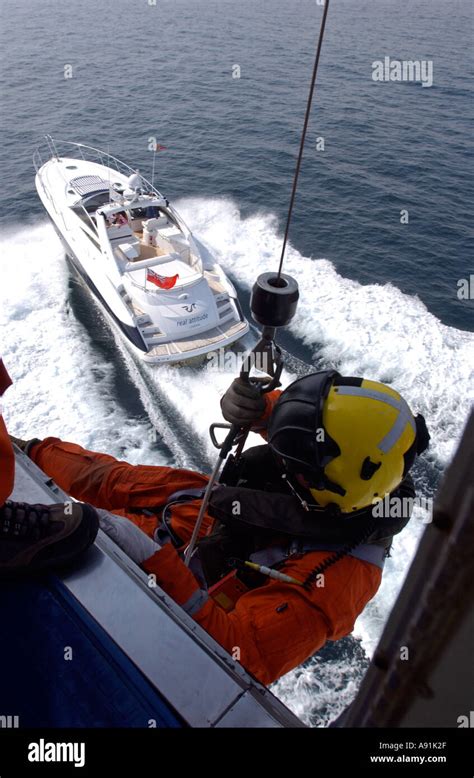 A Winchman Is Lowered To A Speed Boat During A Coastguard Rescue