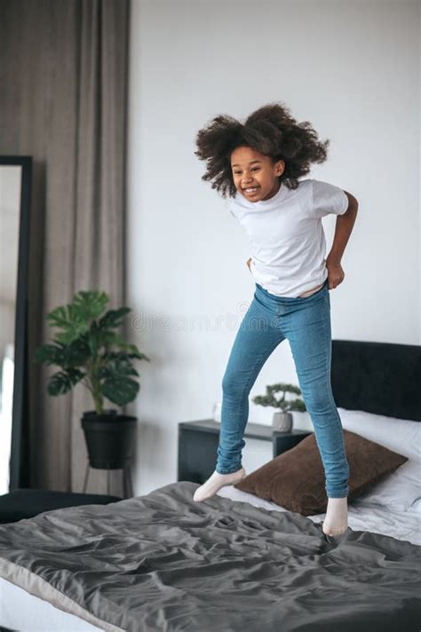 A Cute Curly Haired Girl Having Fun And Looking Enjoyed Stock Image