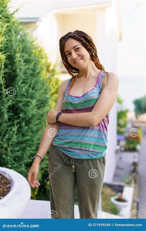 A Girl With A Dreadlocked Hairstyle Poses In The Summer On The Street