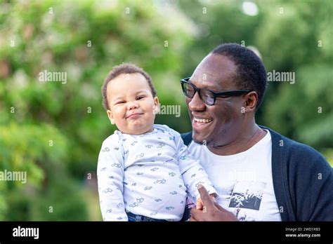Father cuddling adorable biracial baby boy, little African American boy