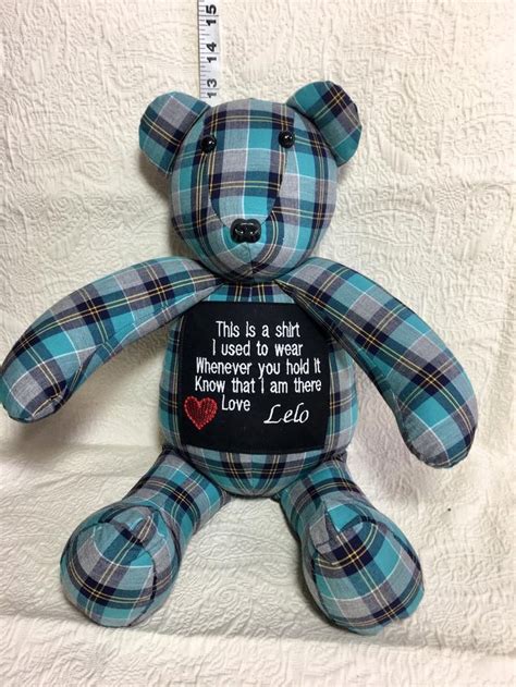 A Blue Plaid Teddy Bear Sitting On Top Of A White Sheet With The Words