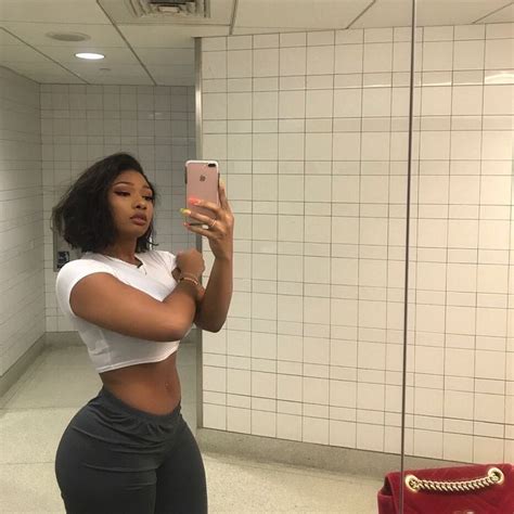 a woman is taking a selfie in the bathroom while wearing leggings and a crop top