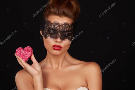 Young Beautiful Sexy Woman With Dark Lace On Eyes Bare Shoulders And Neck Holding Cake Shape Of