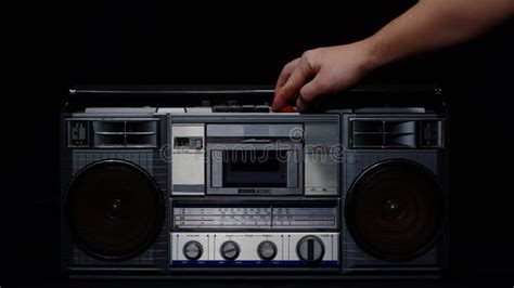 A Manand X27s Hand Inserts A Cassette Into A Tape Recorder And Presses