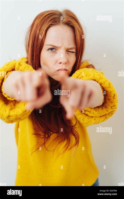 Angry Young Redhead Woman Pointing Her Fingers In Blame With One Eye
