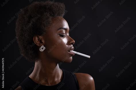 Sexy African American Woman Smoking Cigarette On Black Background