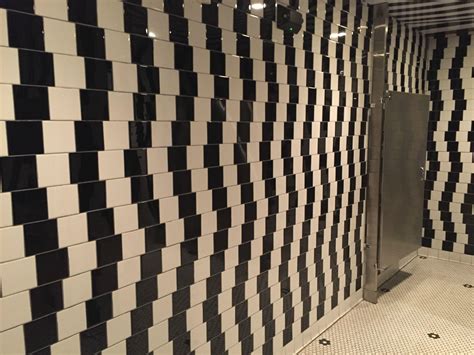 A Tiled Bathroom With Black And White Tiles On The Walls