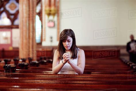 Kneeling Caucasian Woman Praying In Church Pew Stock Photo Dissolve