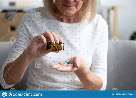 serious mature woman taking out pills from bottle close up stock image image of concept
