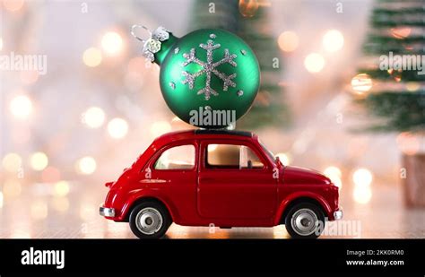 Little Red Car With Green Christmas Ornament On The Roof And Blinking