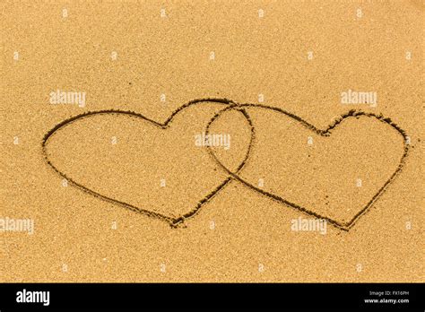 Two Entangled Hearts Drawn Out On A Sandy Beach Stock Photo Alamy