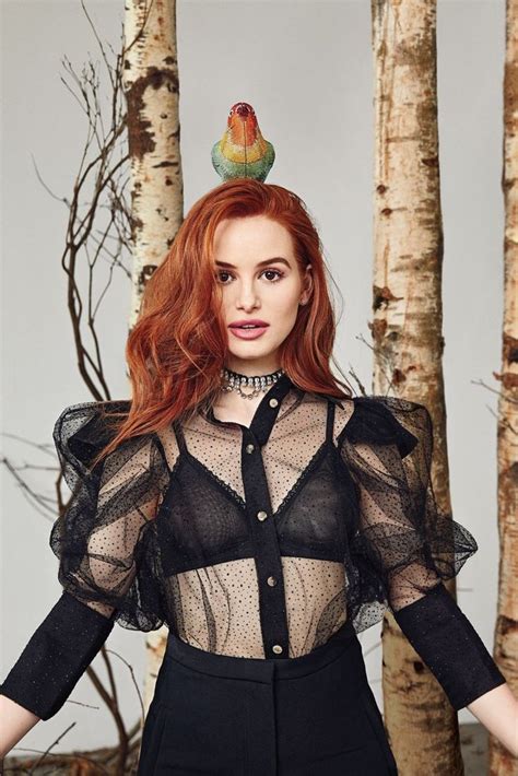 A Woman With Red Hair Wearing A Sheer Shirt And Black Pants Standing In