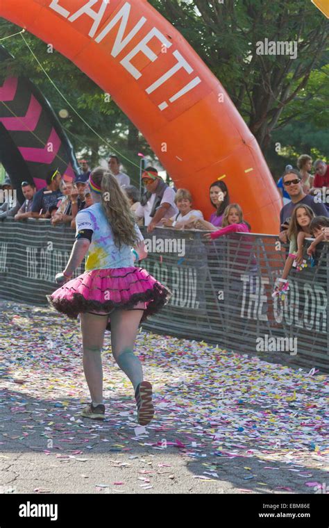 A Happy Runner Splattered With Colorful Dyes Approaches The Finish Line In The Asheville 5k