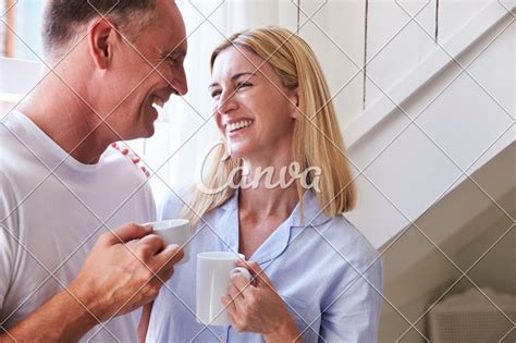 Mature Couple Standing By Bedroom Window With Hot Drink Photos By Canva