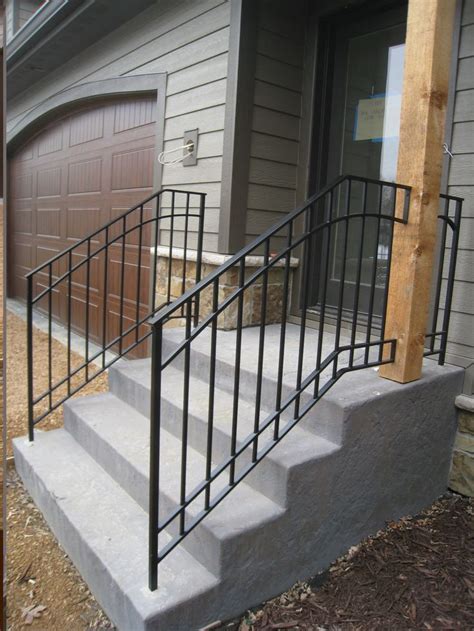 A Metal Hand Rail Is On The Front Steps Of A House