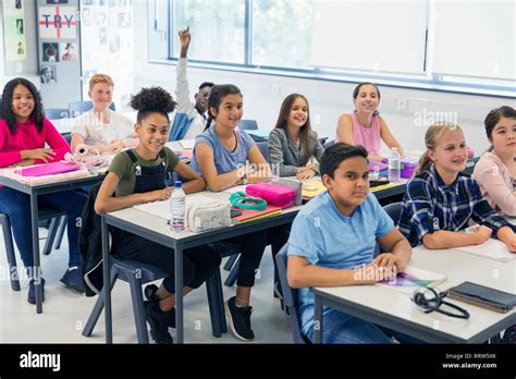 Junior High School Students Enjoying Lesson At Desks In Classroom Stock