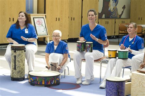 Employees Participating In Drum Demonstration At The Expressive Therapy