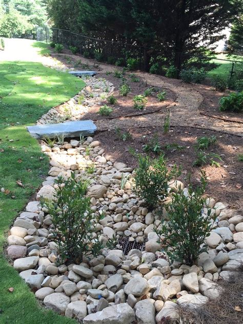 Each section of the lawn edging has a. 2'x4' stone bridge, plantings, sod, river rock dry creek ...