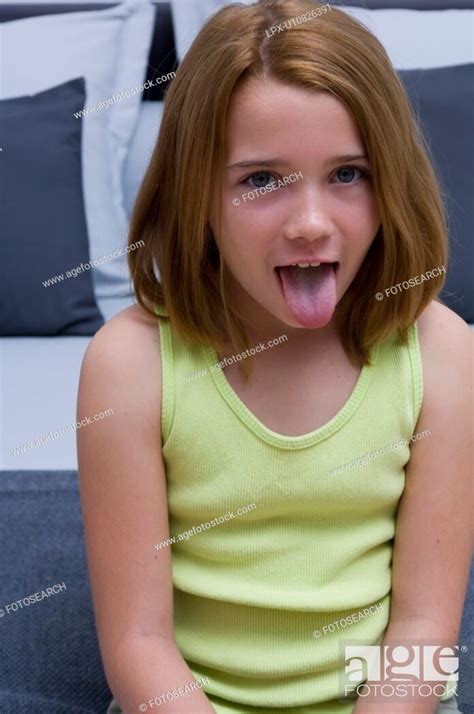 Portrait Of A Young Girl Sticking Out Her Tongue Stock Photo Picture