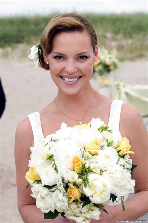 A Woman Holding A Bouquet Of White And Yellow Flowers In Her Hands On