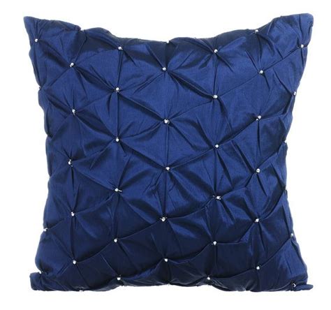 A Blue Pillow With White Studding On The Front And Back Of It Against