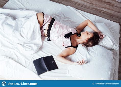 Girl In Pajamas Lying On The Bed With A Book Before Bed Stock Image
