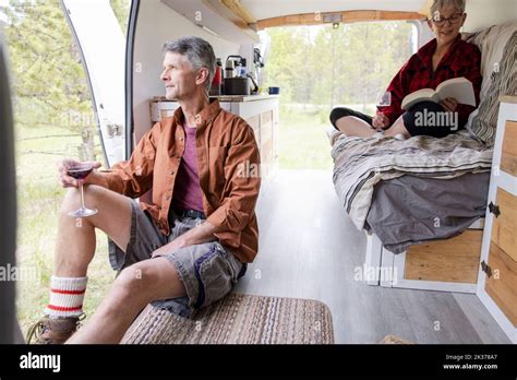 Couple Reading And Drinking Wine In Camper Van Stock Photo Alamy