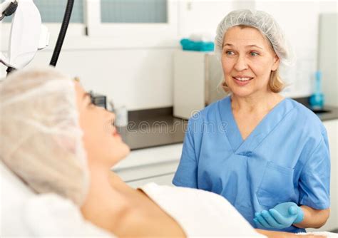 Skillful Cosmetologist Consulting Young Woman In Medical Esthetic