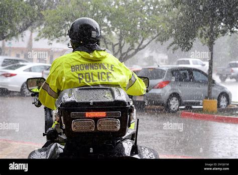 An officer rides out into the pouring rain on his police motorcycle