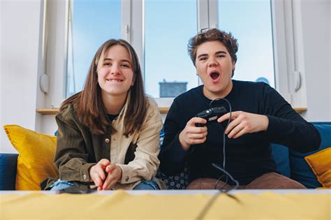 Teenage Boy With Controller Playing Video Game Excitedly His Female