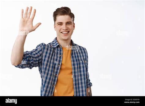 Portrait Of Friendly Smiling Man Waving Raised Hand Saying Hello And