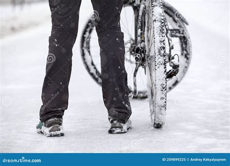 Snowy Bike Wheels And Bicyclist Legs And Shoes Person With Bicycle