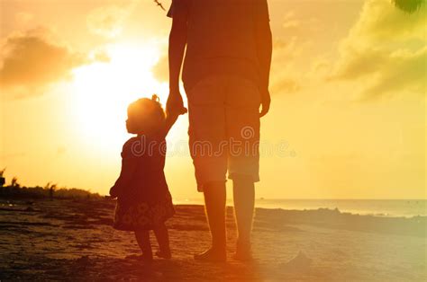 Padre Y Pequeña Hija Que Caminan En La Playa En Foto De Archivo