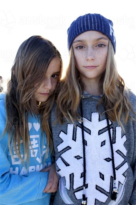 Image Of Two Girls Standing Next To Each Other Looking Serious