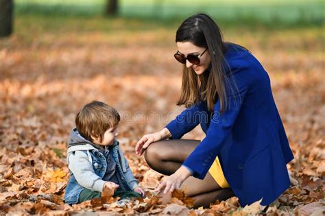 Young Mother Walking With A Small Child In The Autumn Park Stock Image
