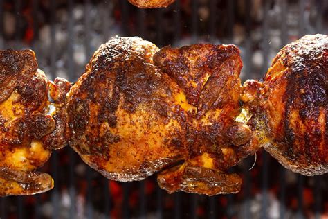 Rotisserie Roasted Chickens On Spit Grilled Over Fire Of A Big