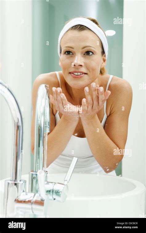 Woman Washing Her Face In Bathroom Stock Photo Alamy