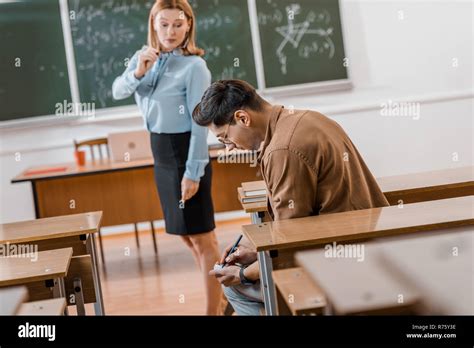 Selective Focus Of Dissatisfied Female Teacher Looking At Male Student