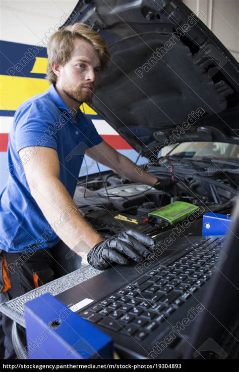 Mechaniker Fixiert Einen Automotor Während Er In Lizenzfreies Bild