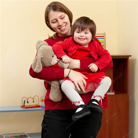Premium Photo Woman Holding Smiley Child With Down Syndrome